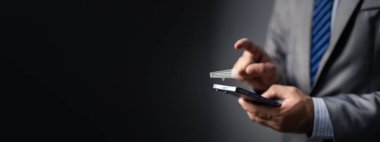 Takım elbiseli biri cep telefonunda sohbet mesajı yazıyor, iş adamı arkadaşlarıyla konuşmak ve iş konuşmak için akıllı telefondaki sohbet uygulaması ile mesajlaşıyor. İletişim için teknolojiyi kullanma kavramı.