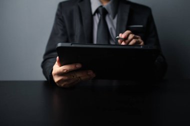 Business men are looking at the company's financial documents on tablets to analyze problems and find solutions before bringing the information to a meeting with a partner. Financial concept.