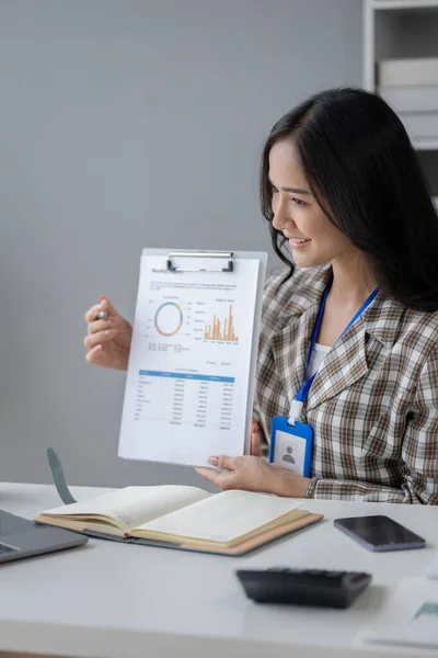 stock image Young beautiful asian woman working in corporate office, businesswoman working in office attentively to grow and modernize start-up business, she is analyzing company's market and financial data.