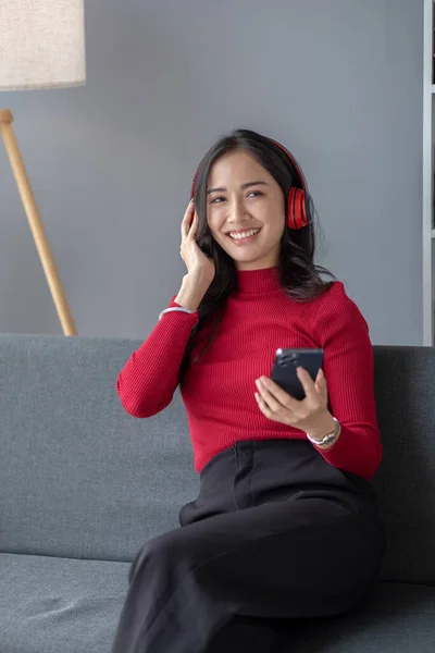 stock image Asian beautiful woman sits in living room, she is college student listening to relaxing music, studying from home, online learning. University student concept.