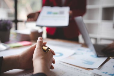 Businessman is reviewing monthly sales documents for analysis and marketing plans for more sales growth, they are the founders of young companies co-founding startups. Sales management concept.