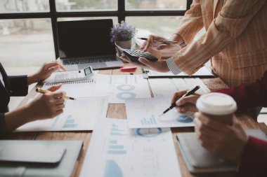 Businessman is reviewing monthly sales documents for analysis and marketing plans for more sales growth, they are the founders of young companies co-founding startups. Sales management concept.