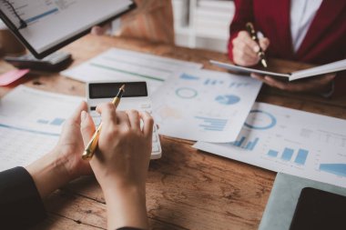 Businessman is reviewing monthly sales documents for analysis and marketing plans for more sales growth, they are the founders of young companies co-founding startups. Sales management concept.