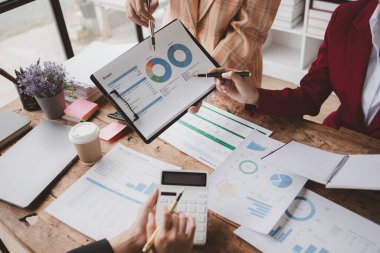 Businessman is reviewing monthly sales documents for analysis and marketing plans for more sales growth, they are the founders of young companies co-founding startups. Sales management concept.