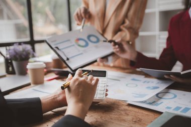 Businessman is reviewing monthly sales documents for analysis and marketing plans for more sales growth, they are the founders of young companies co-founding startups. Sales management concept.