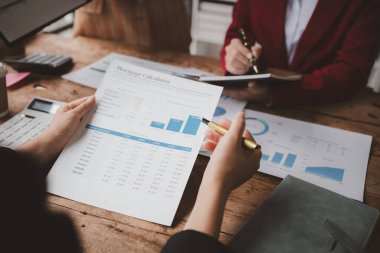 Businessman is reviewing monthly sales documents for analysis and marketing plans for more sales growth, they are the founders of young companies co-founding startups. Sales management concept.