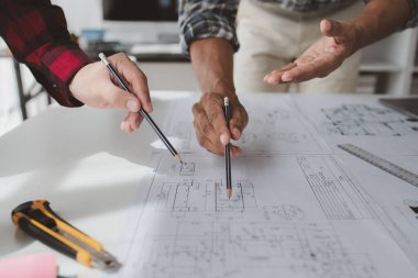 The home design architects are reviewing the house plan draft, the project commissioned by the client, and the custom design before delivery. Interior design and decoration ideas.