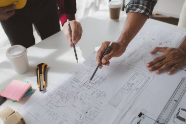 The home design architects are reviewing the house plan draft, the project commissioned by the client, and the custom design before delivery. Interior design and decoration ideas.