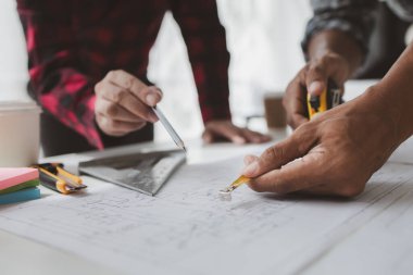 The home design architects are reviewing the house plan draft, the project commissioned by the client, and the custom design before delivery. Interior design and decoration ideas.