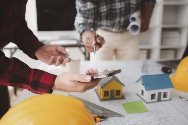 The home design architects are reviewing the house plan draft, the project commissioned by the client, and the custom design before delivery. Interior design and decoration ideas.