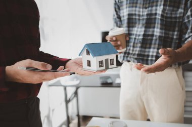 The home design architects are reviewing the house plan draft, the project commissioned by the client, and the custom design before delivery. Interior design and decoration ideas.