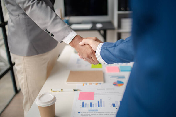 Two business men shake hands, Two businessmen are agreeing on business together and shaking hands after a successful negotiation. Handshaking is a Western greeting or congratulation.