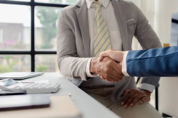 stock image Two business men shake hands, Two businessmen are agreeing on business together and shaking hands after a successful negotiation. Handshaking is a Western greeting or congratulation.