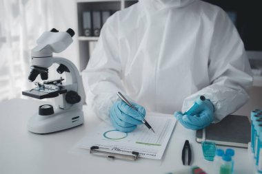 Lab practitioner working on chemical research for chemical reactions, does a chemical experiment and examines a patient's blood sample. Medicine and research concept.