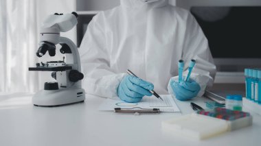 Lab practitioner working on chemical research for chemical reactions, does a chemical experiment and examines a patient's blood sample. Medicine and research concept.