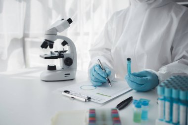 Lab practitioner working on chemical research for chemical reactions, does a chemical experiment and examines a patient's blood sample. Medicine and research concept.