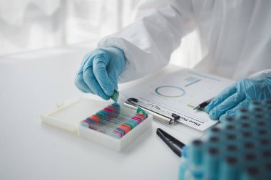 Lab practitioner working on chemical research for chemical reactions, does a chemical experiment and examines a patient's blood sample. Medicine and research concept.