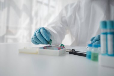 Lab practitioner working on chemical research for chemical reactions, does a chemical experiment and examines a patient's blood sample. Medicine and research concept.