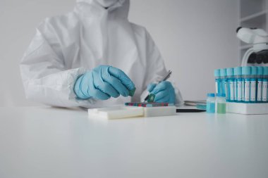 Lab practitioner working on chemical research for chemical reactions, does a chemical experiment and examines a patient's blood sample. Medicine and research concept.