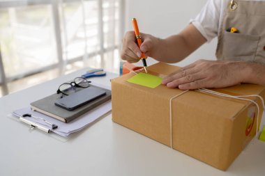 Web sitesindeki bir çevrimiçi mağazanın sahibi, çevrimiçi dükkan sahibi ürünleri web sitesinde dağıtıyor, siparişlere göre ürünleri paketliyor ve özel nakliye şirketi tarafından dağıtılıyor. Çevrimiçi alışveriş kavramı.