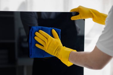 Temizlik odası, temizlik işçisi şirket ofisindeki bilgisayar ekranını silmek için bez kullanıyor. Temizlik personeli. Örgütteki temizlik kavramı.