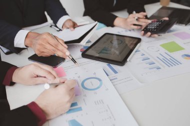 Businessman is reviewing monthly sales documents for analysis and marketing plans for more sales growth, they are the founders of young companies co-founding startups. Sales management concept.