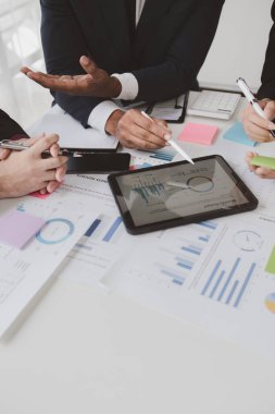 Businessman is reviewing monthly sales documents for analysis and marketing plans for more sales growth, they are the founders of young companies co-founding startups. Sales management concept.