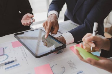 Businessman is reviewing monthly sales documents for analysis and marketing plans for more sales growth, they are the founders of young companies co-founding startups. Sales management concept.