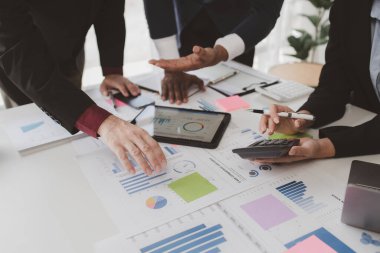 Businessman is reviewing monthly sales documents for analysis and marketing plans for more sales growth, they are the founders of young companies co-founding startups. Sales management concept.