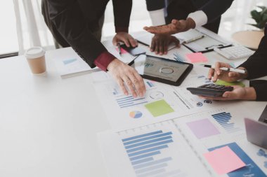 Businessman is reviewing monthly sales documents for analysis and marketing plans for more sales growth, they are the founders of young companies co-founding startups. Sales management concept.
