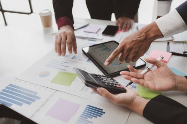 Businessman is reviewing monthly sales documents for analysis and marketing plans for more sales growth, they are the founders of young companies co-founding startups. Sales management concept.