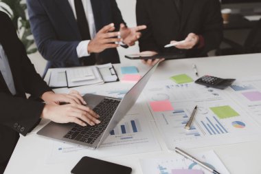 Businessman is reviewing monthly sales documents for analysis and marketing plans for more sales growth, they are the founders of young companies co-founding startups. Sales management concept.