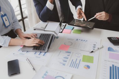 Businessman is reviewing monthly sales documents for analysis and marketing plans for more sales growth, they are the founders of young companies co-founding startups. Sales management concept.