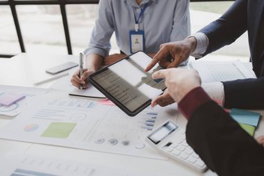 The sales department is having a monthly summary meeting to bring it to the department manager, they are verifying the correctness of the documents that are prepared before bringing in to the manager