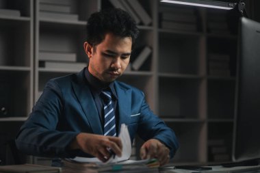 Erkek çalışan gecenin bir yarısı ofiste, yeni başlayan bir şirkette fazla mesai yapıyor, çok çalışıyor ve fazla mesai yapıyor. Fazla mesai konsepti. Özel şirketlerin çalışanları..