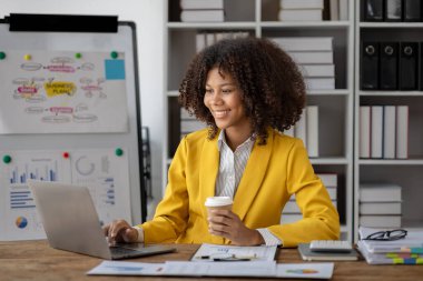 Girişim şirketinde oturan Amerikalı kadın, ofiste çalışan Amerikalı iş kadını, şirketin satışlarını artırmak için pazarlama ve planlama stratejileri üzerinde çalışıyor. Stratejik planlama kavramı.
