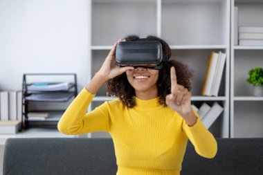 Amerikalı bir kadın hafta sonları oturma odasında oturur, VR gözlükleri takar, oyunlar oynar, iş haftasından dinlenmek için izin alır. Hafta sonları etkinlik yapmak için fikirler.