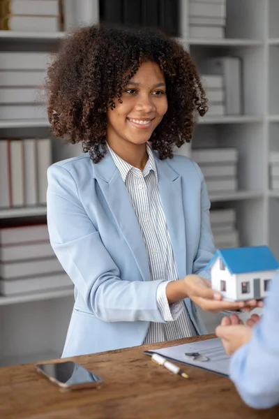 An American woman is a land and real estate broker for houses and condos, she is a real estate broker recommending houses to clients. Real estate trading concept.