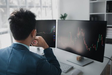 Hisse senedi yatırımcısı, işadamı kar elde etmek için hisse senedi ticareti yapıyor, borsada salınım gösteren grafik ekranı, yatırım yönetimi, hisse senedi kar ticaretini analiz ediyor. Hisselere yatırım yapma kavramı.