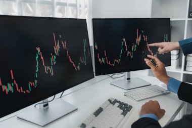 Borsa grafik ekranı olan iki yatırımcı, hisse senedi dalgalanması analizi, kar için hisse senedi alım satımı, borsa dalgalanması grafik ekranı, kar ticaret analizi.