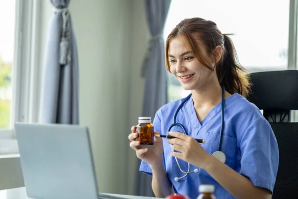 Beautiful young female doctor in medical uniform is introducing and consulting treatment via video call with patient, medical professional doctor and consulting, treatment. Female doctor concept.