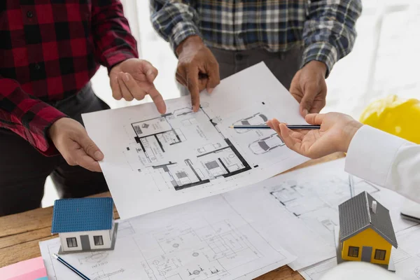 インテリアデザイナーとエンジニアと建築家は 設計原則と計画に従って家の建設を計画するために協力して 彼らはレビューし 修正を行う計画を見ています — ストック写真