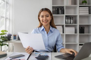 Girişim şirketinde çalışan Asyalı bir kadın, şirket raporlarını inceleyip şirket geliştirmenin yollarını arayan bir iş kadını. İş yönetimi kavramı.