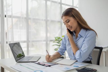 Asyalı kadın şirket ofisinde telefonla konuşuyor, iş kadını üst düzey yönetici şirket yöneticisi ofiste telefonla konuşuyor, iş görüşmeleri. İş yönetimi kavramı.