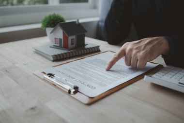 Ev satış temsilcileri ve satış temsilcileri projedeki evleri görmek isteyen müşterilere projede konut detaylarını tavsiye ediyorlar. Gayrimenkul ticareti.