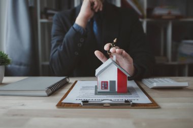 Ev satış temsilcileri ve satış temsilcileri projedeki evleri görmek isteyen müşterilere projede konut detaylarını tavsiye ediyorlar. Gayrimenkul ticareti.