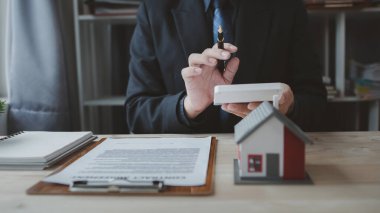 Ev satış temsilcileri ve satış temsilcileri projedeki evleri görmek isteyen müşterilere projede konut detaylarını tavsiye ediyorlar. Gayrimenkul ticareti.