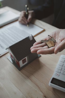 Ev satış temsilcileri ve satış temsilcileri projedeki evleri görmek isteyen müşterilere projede konut detaylarını tavsiye ediyorlar. Gayrimenkul ticareti.