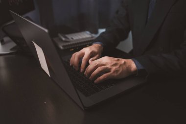 Dizüstü bilgisayarın klavyesinde yazan kişi, hisse senedi yatırımcısı, hisse senedi alım-satımı, karlı ticaret için borsa analizi, kripto para yatırımı. Hisselere yatırım yapma kavramı.
