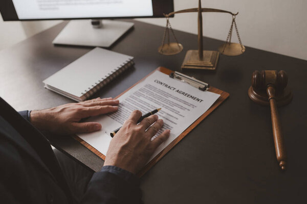 Lawyer sits in office with litigation contract documents, attorneys draft contracts and legal terms for clients for litigation, fair and transparent litigation. Lawyer concept and litigation.